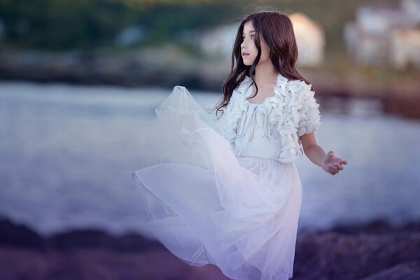 The girl is spinning in a beautiful white dress