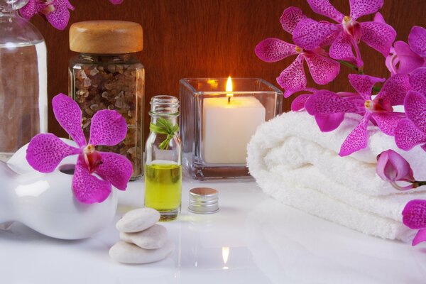 Terry towel and aroma candle surrounded by flowers