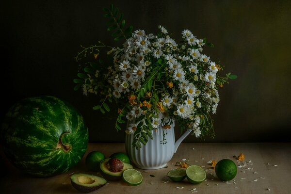 Stillleben aus Blumen, Wassermelone, gehackten Limetten und Avocado