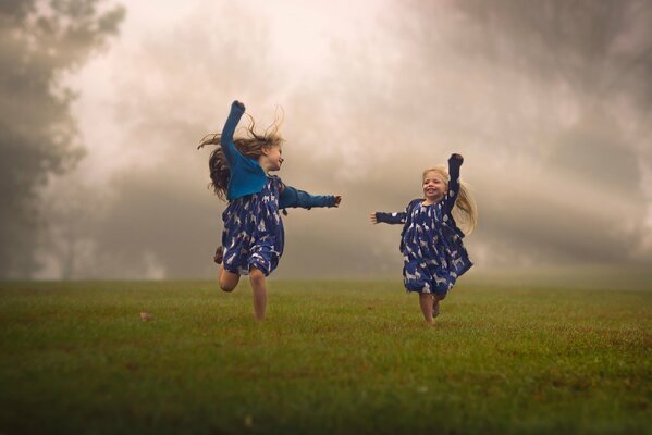 Children frolic in a foggy field