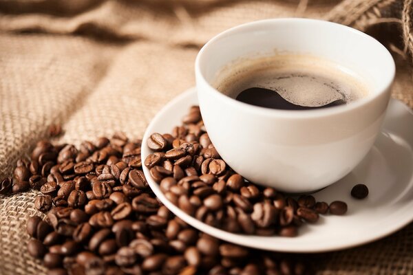 Grain de boisson de café dans une tasse blanche avec soucoupe