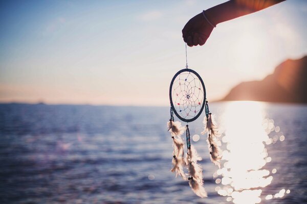 Dreamcatcher on the background of the river sun