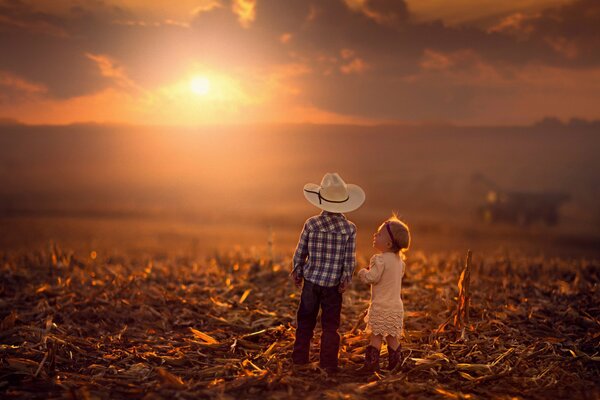 Ragazzo e ragazza nel campo sullo sfondo del tramonto d autunno