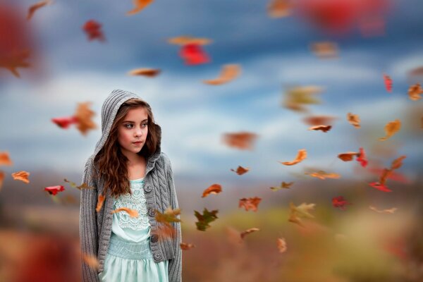 Foto di una ragazza in posa su uno sfondo di foglie d autunno