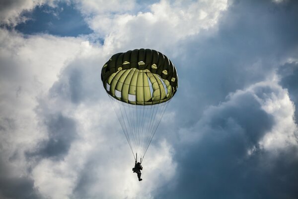 A skydiver makes a jump. Blue sky in clouds