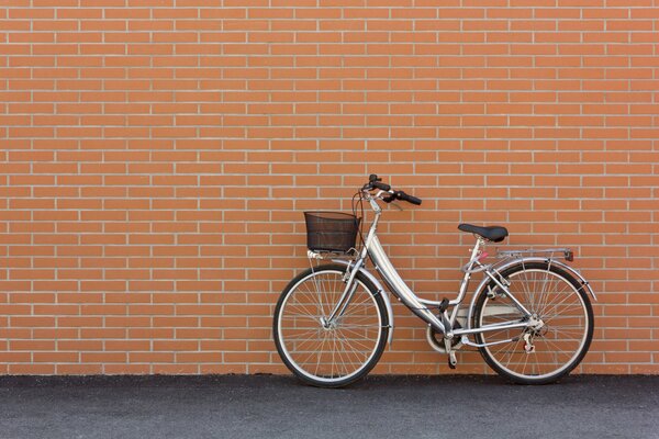 Silver bicycle on the background of a brick wall