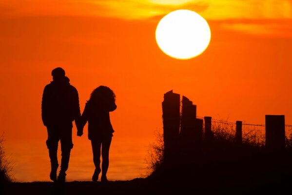 Couple s éloigne dans un beau coucher de soleil