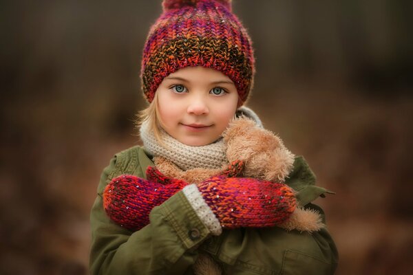 Retrato de una niña con un oso en un fondo borroso