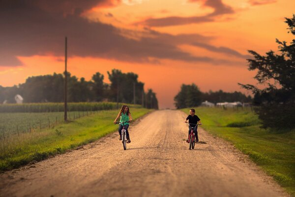 A girl and a boy ride bicycles