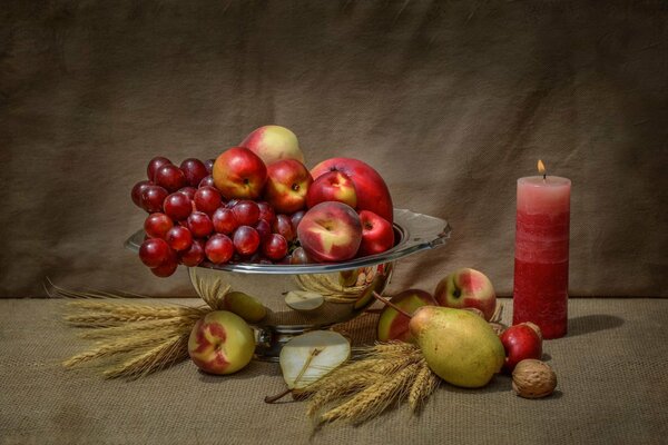 Bodegón florero con frutas y velas rojas