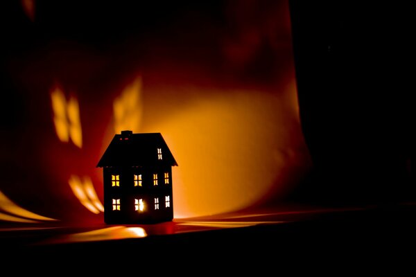 Casa lampada al buio con una candela all interno