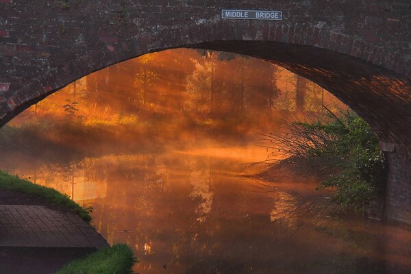 Bild einer Brücke über dem Fluss bei Sonnenuntergang