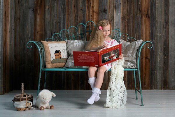 A girl is reading a book on the couch