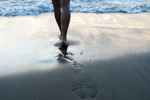 A woman goes to the sea and leaves footprints in the sand