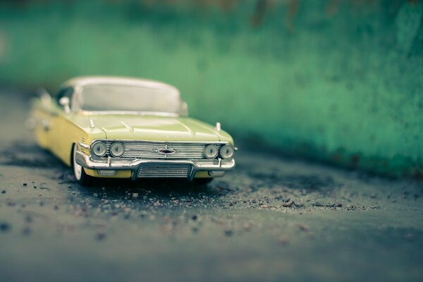 A toy, yellow car on the road