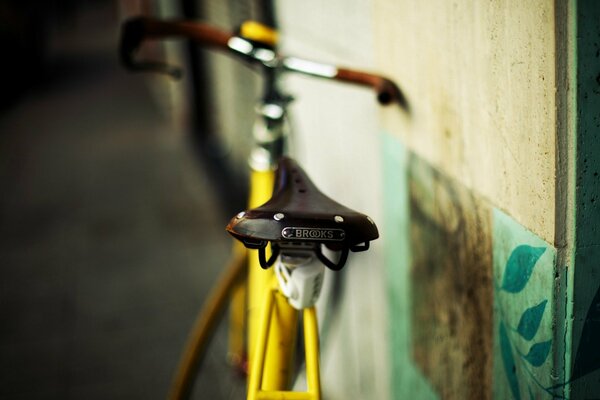 Bicicleta amarilla apoyada contra la pared