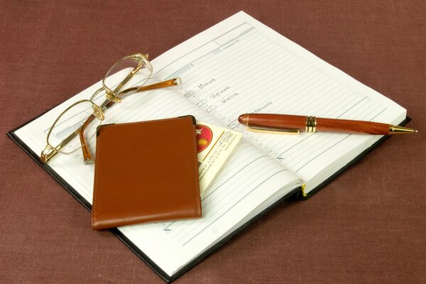 Glasses, business card holder, pen, notebook in brown