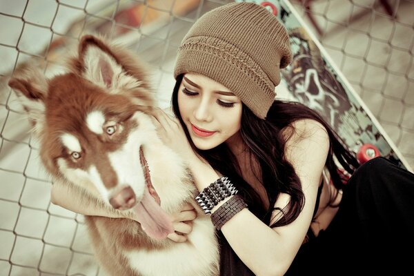 Ragazza in cappello con cane husky