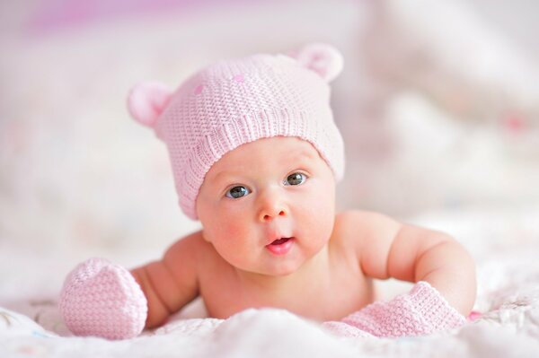 Cute newborn in a pink hat and gloves