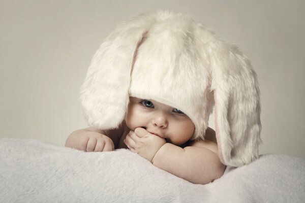 Bambino felice in cappello di pelliccia con orecchie lunghe