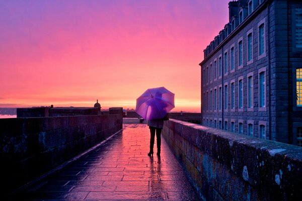 Ragazza sotto l ombrello in mezzo alla città al tramonto