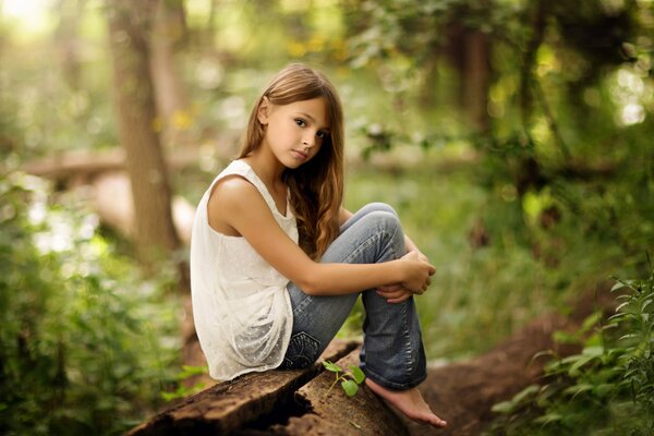 Jeune fille assise dans la nature étreindre ses genoux