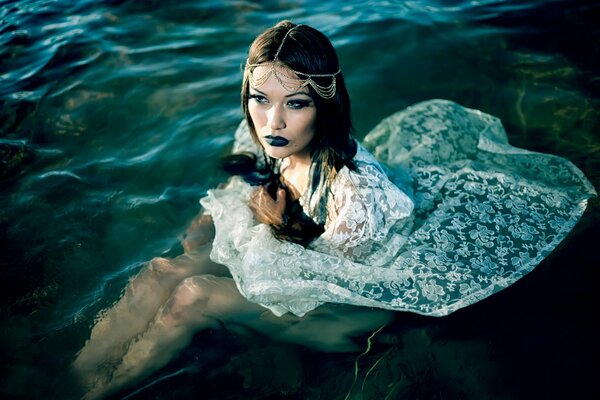 Ragazza in acqua in abito bianco