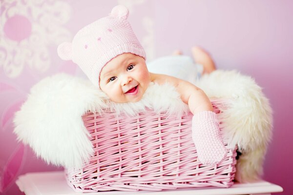 A smiling baby in a pink basket