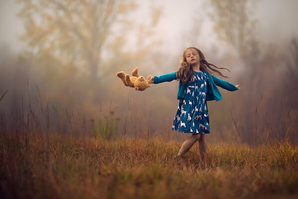 A girl with a teddy bear is spinning