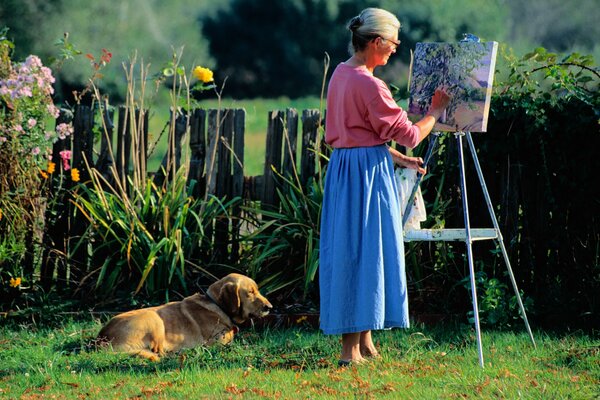 An artist with a dog draws a picture