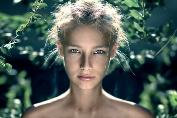 Portrait of a beautiful girl on a background of foliage