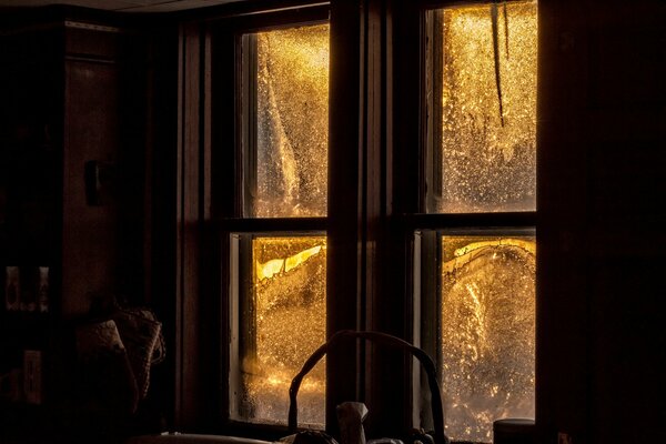 A winter evening and a window with glass in frosty patterns