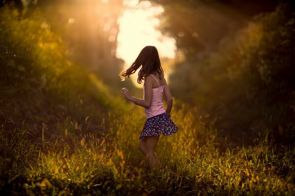 Morning nature, painted with bright colors and illuminated by bright rays of the sun. A little girl running into the light