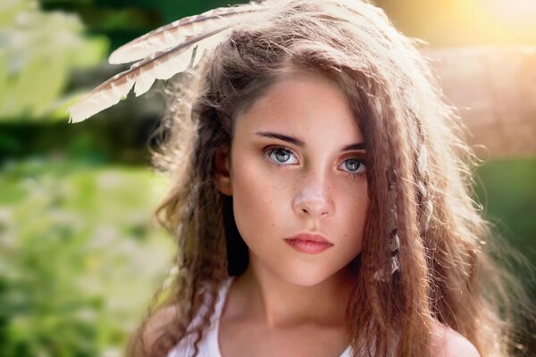 Niña con plumas en la cabeza y cabello rizado