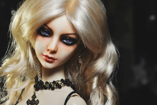 A doll with white hair and a mole above her lip