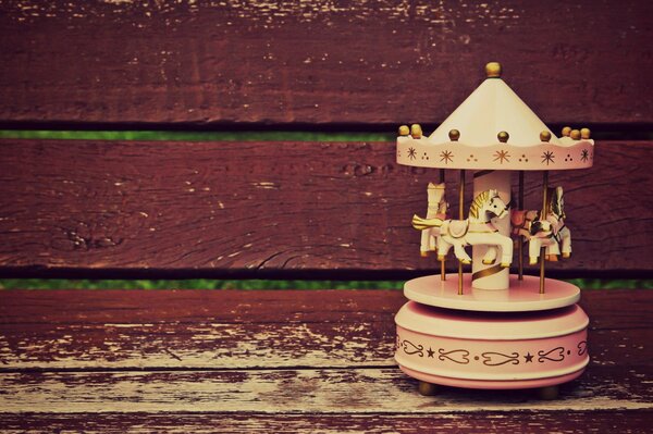 Toy carousel with horses on a bench