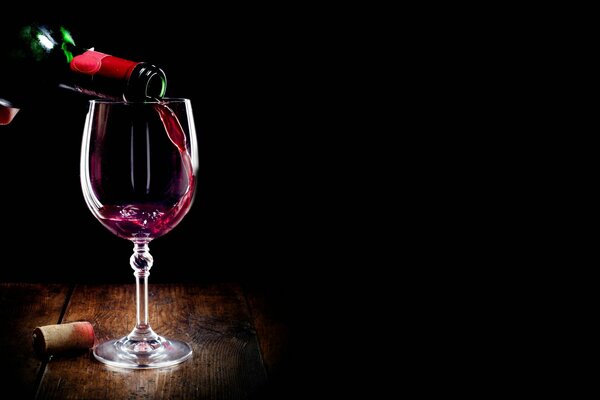 A glass of red wine on a black background