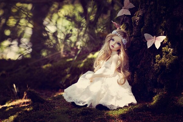 Doll in the forest with butterflies in a beautiful white dress