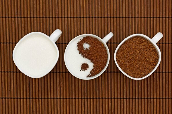 Three cups of coffee and milk depict the Ying-yang symbol