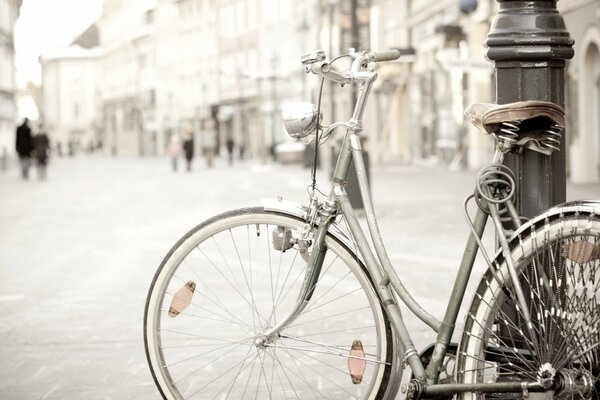 Bicycle supported on a pole street passers-by