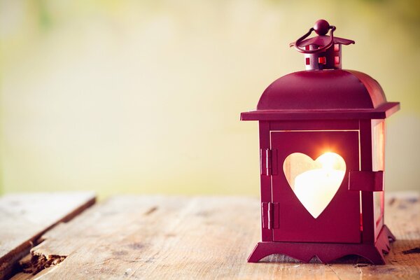 Pink lantern with a hole in the shape of a heart and sun rays