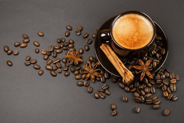 Coffee beans and cinnamon next to a cup of coffee