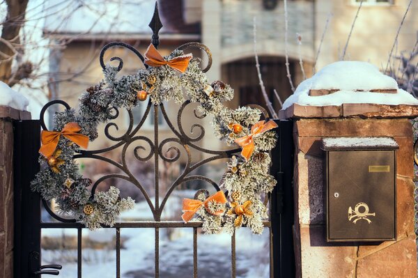 A gate with a Christmas wreath and a mailbox