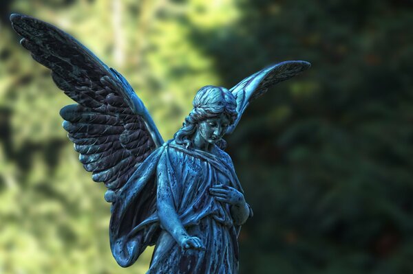 Statue d ange avec des ailes sur fond d arbres