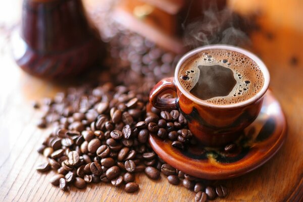 Café chaud avec de la mousse dans une tasse sur une soucoupe