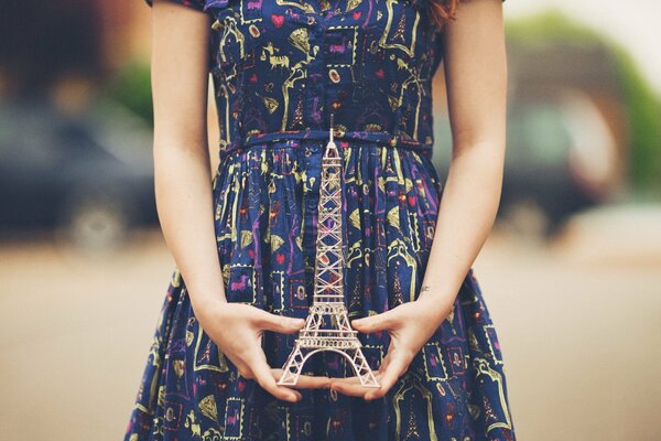 Fille dans les mains tenant une maquette de la tour Eiffel