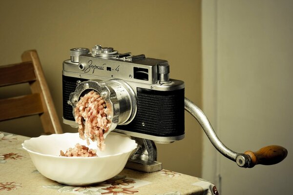 Picadora de carne en forma de fotoaparato en el fondo de la pared