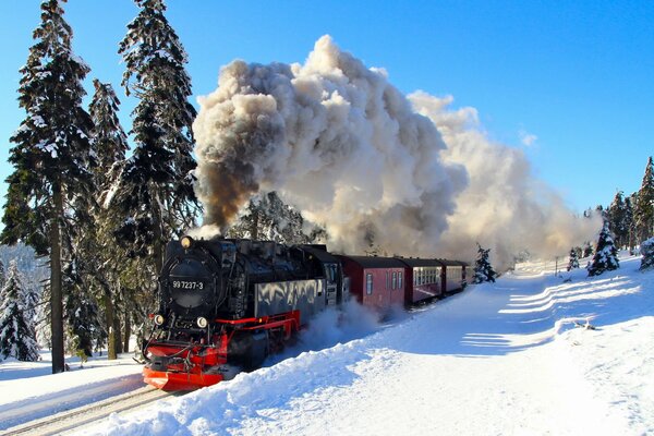 Il treno nero attraversa la strada invernale