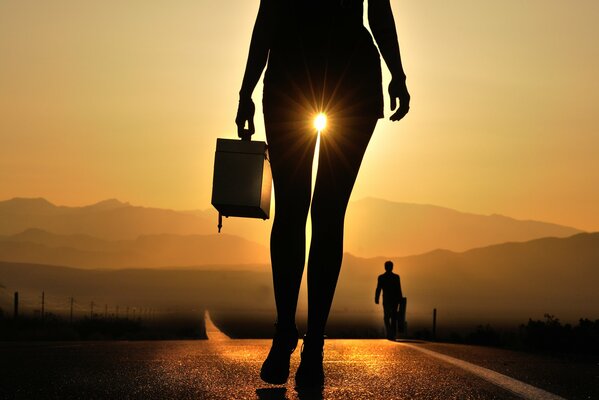 Silhouette of a girl against the background of sunset and road