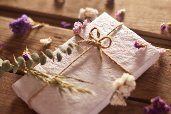 Umschlag in Blumen auf einem Holztisch